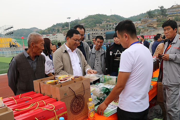 2  政府副县长张小瑞在维宏薯业合作社展位了解产品.JPG